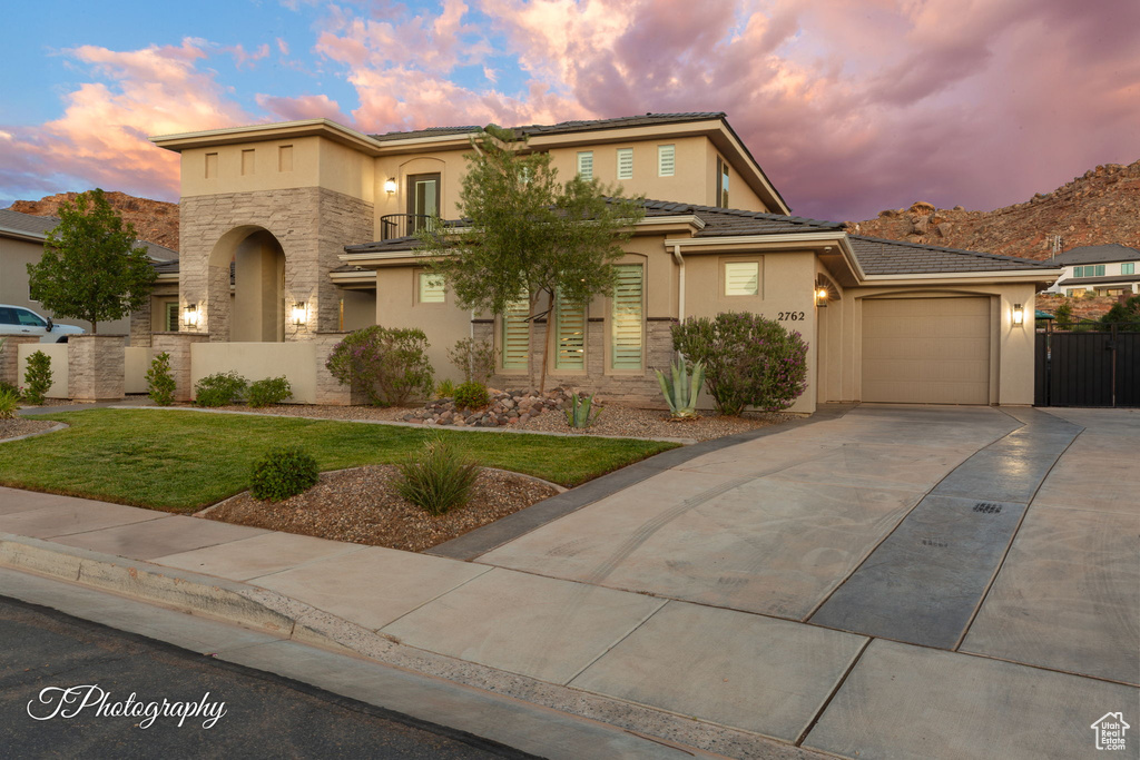 View of front of home featuring stucco siding, concrete driveway, stone siding, and an attached garage