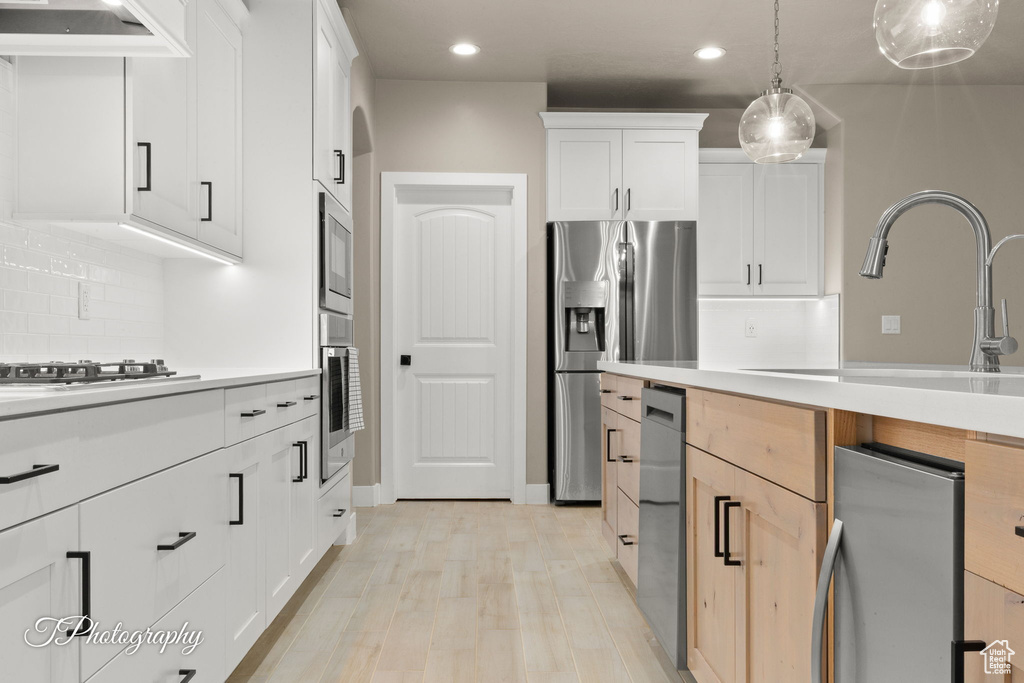 Kitchen with recessed lighting, light countertops, stainless steel appliances, decorative backsplash, and custom range hood