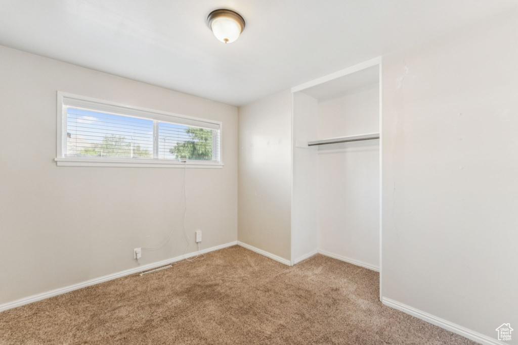 Unfurnished bedroom featuring carpet flooring and a closet