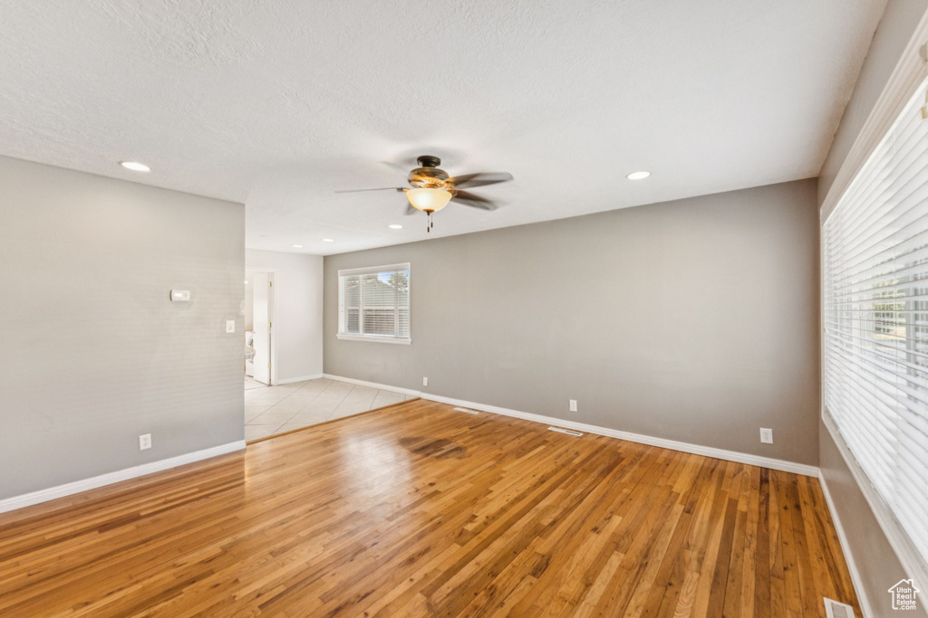 Unfurnished room featuring a ceiling fan, light wood-style flooring, healthy amount of natural light, and recessed lighting