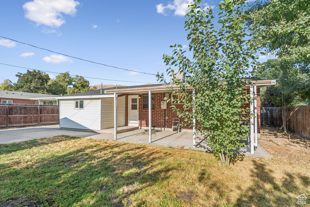 Back of house featuring a patio area, a fenced backyard, and brick siding