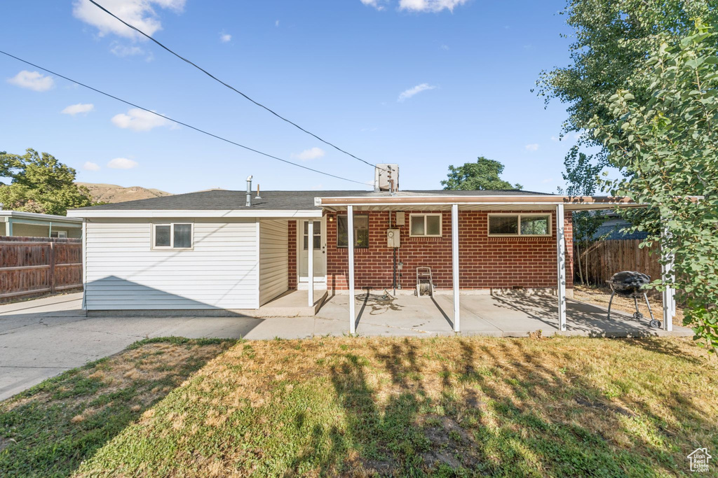 Rear view of house with a patio and brick siding