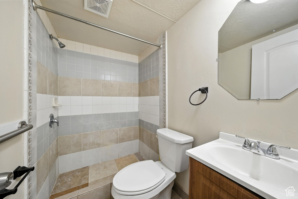 Full bathroom with a tile shower and vanity