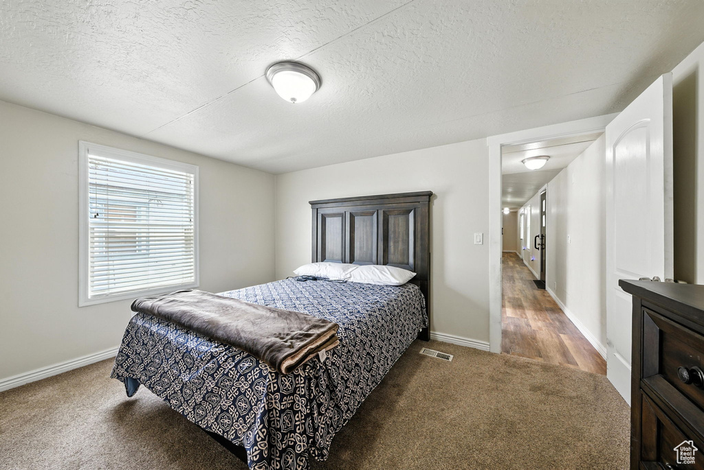Carpeted bedroom featuring a textured ceiling
