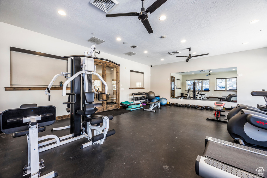 Gym featuring a ceiling fan, recessed lighting, and a textured ceiling