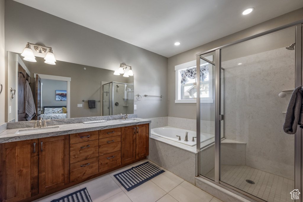 Ensuite bathroom with a bath, a shower stall, tile patterned floors, double vanity, and recessed lighting
