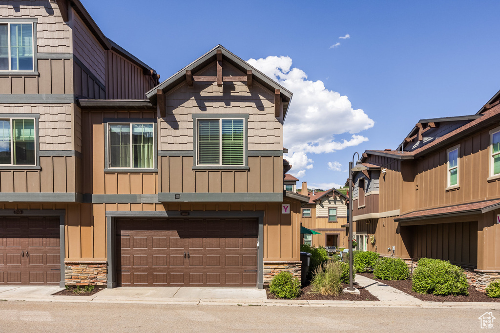 Multi unit property with board and batten siding, stone siding, and a garage