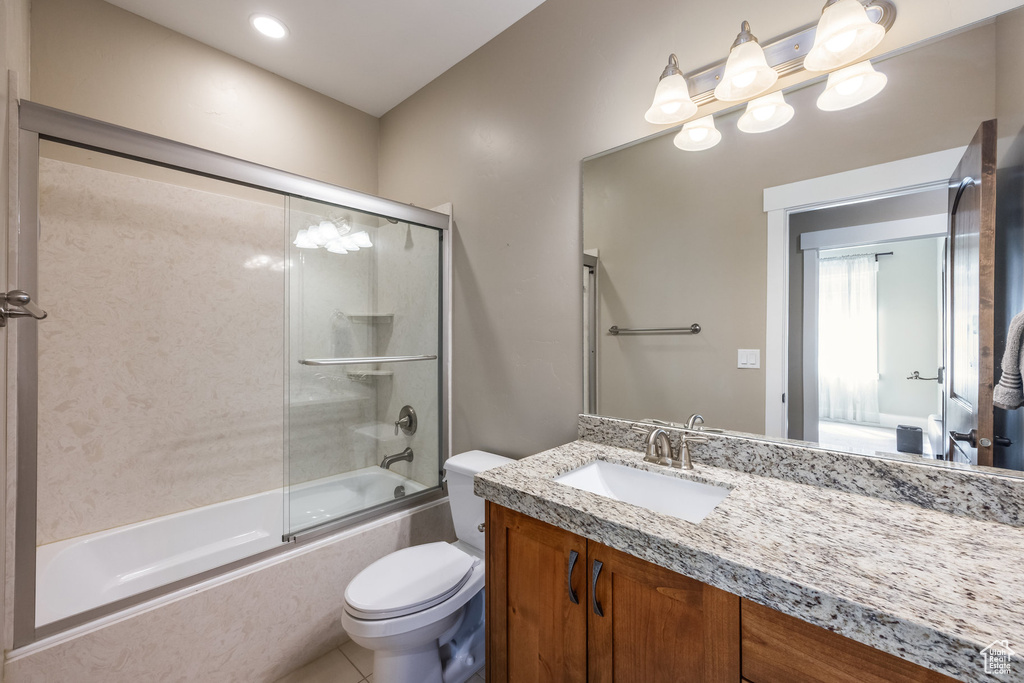 Bathroom featuring combined bath / shower with glass door, vanity, and tile patterned flooring