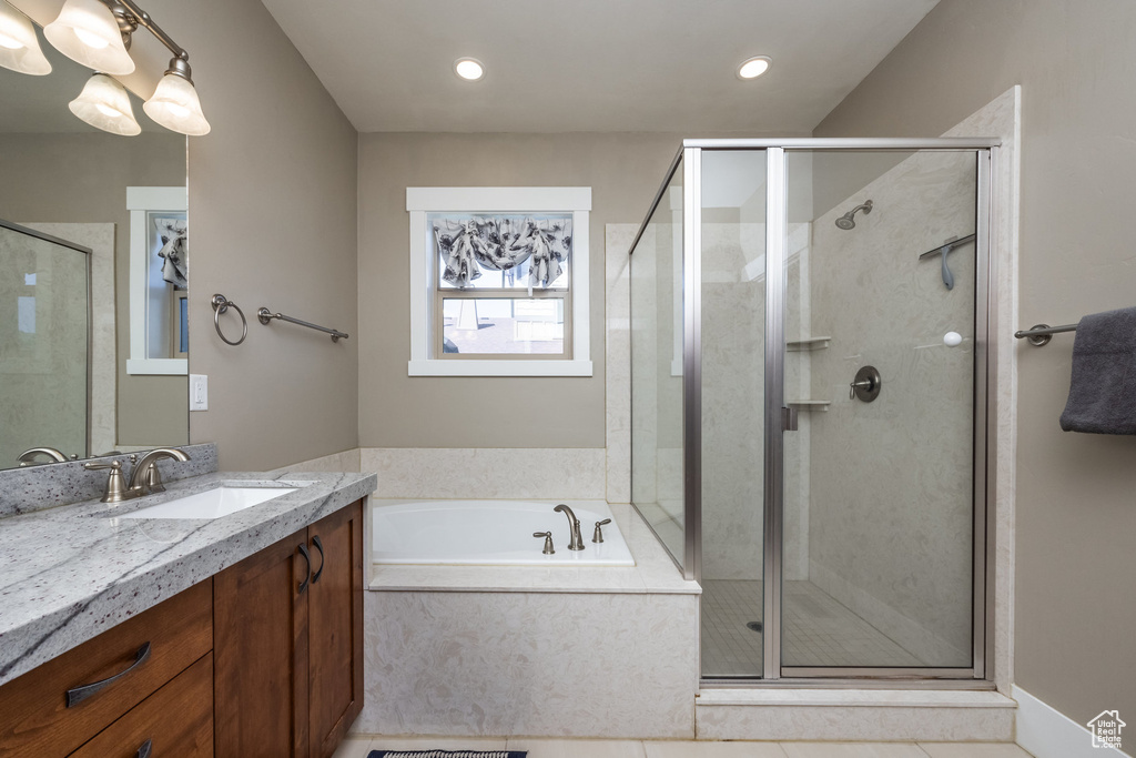 Bathroom with a bath, vanity, a shower stall, and recessed lighting