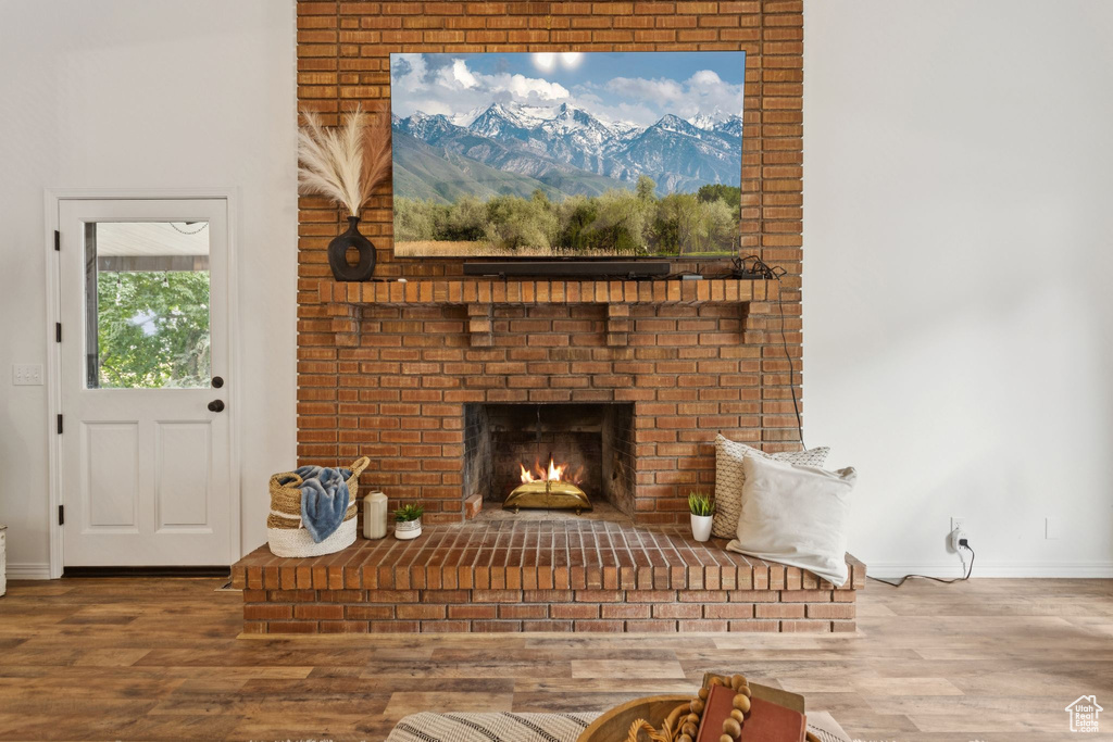 Living area with wood finished floors and a brick fireplace