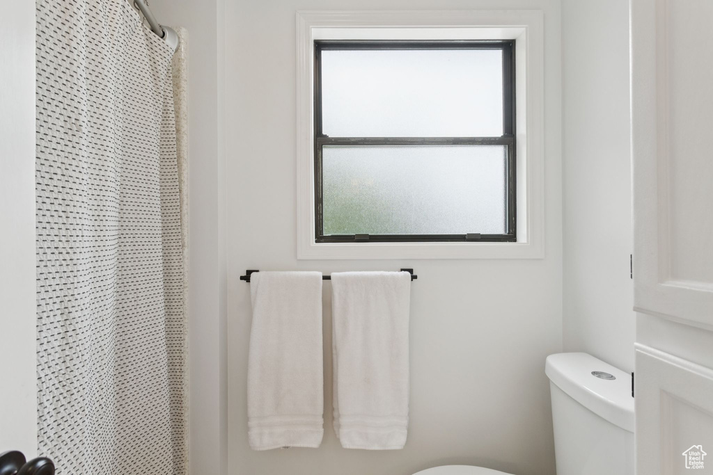 Full bathroom featuring toilet and a shower with curtain