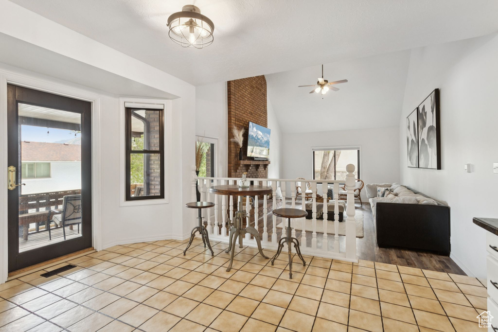 Dining room with lofted ceiling, a ceiling fan, and light tile patterned floors
