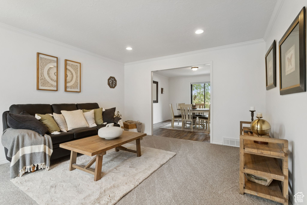 Carpeted living room with ornamental molding and recessed lighting