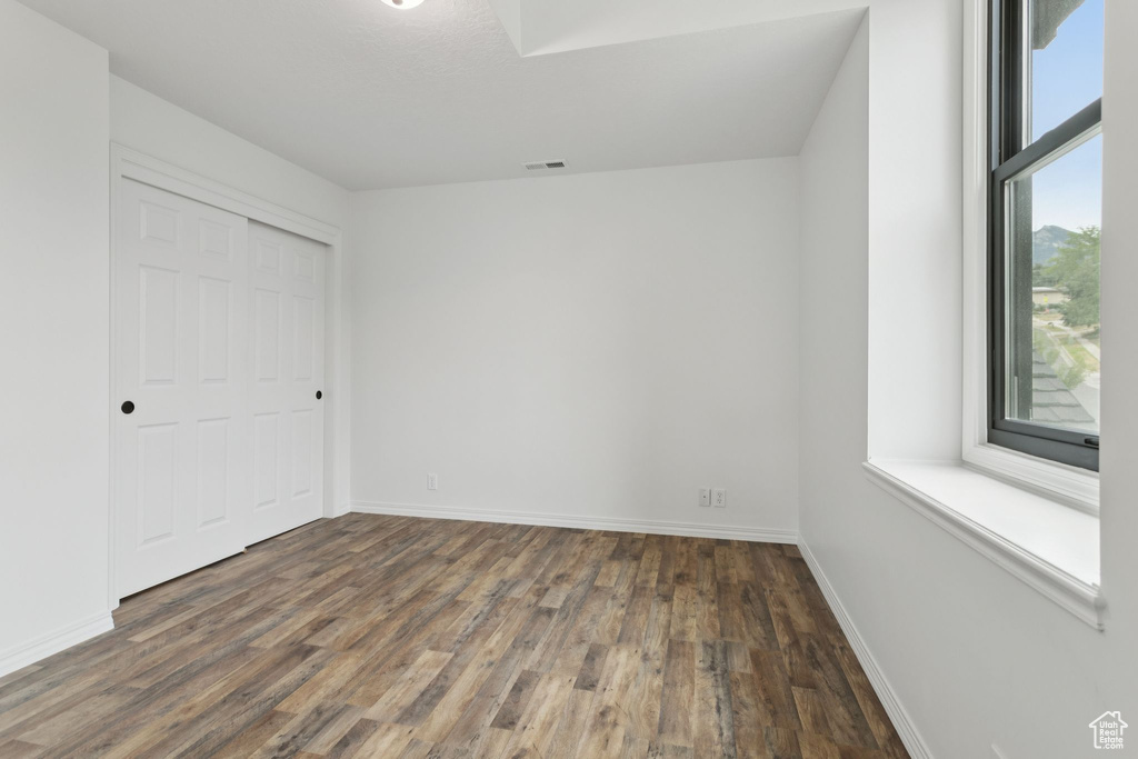 Unfurnished bedroom featuring wood finished floors and a closet
