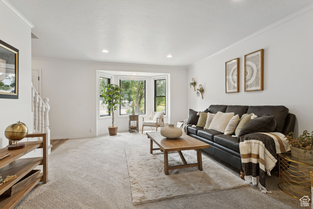 Living room with crown molding, carpet, recessed lighting, and stairway