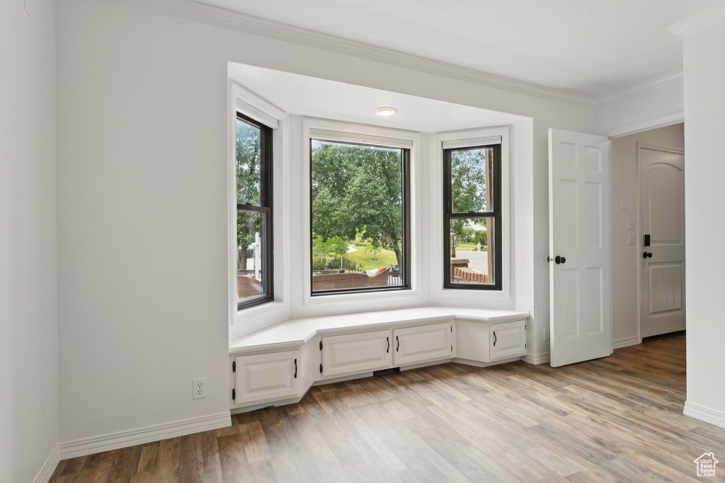 Unfurnished room featuring light wood-type flooring and crown molding