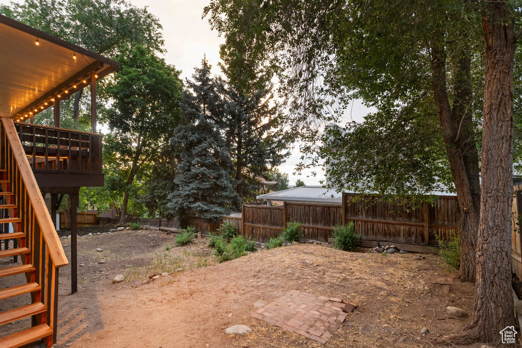 Fenced backyard with stairs and a deck