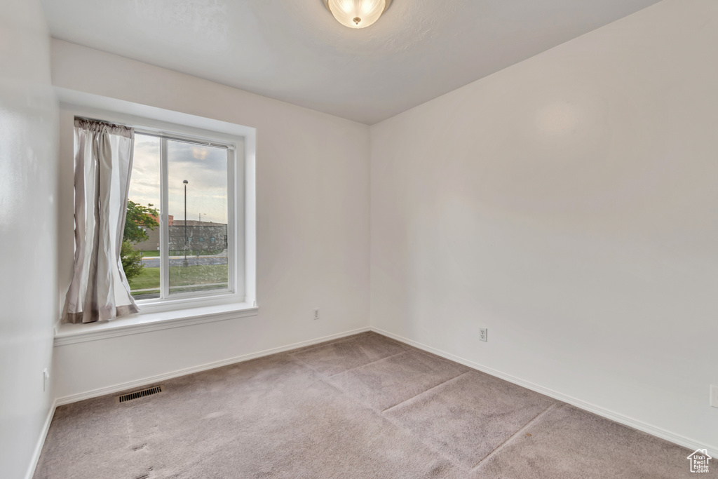 Unfurnished room with carpet flooring and baseboards