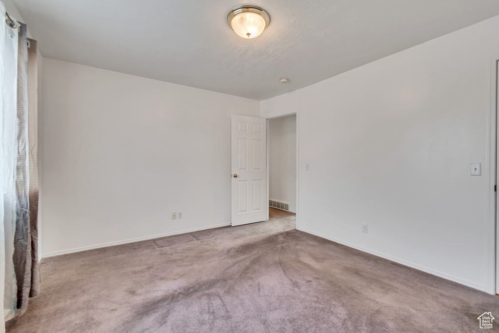 Unfurnished room featuring carpet floors and baseboards