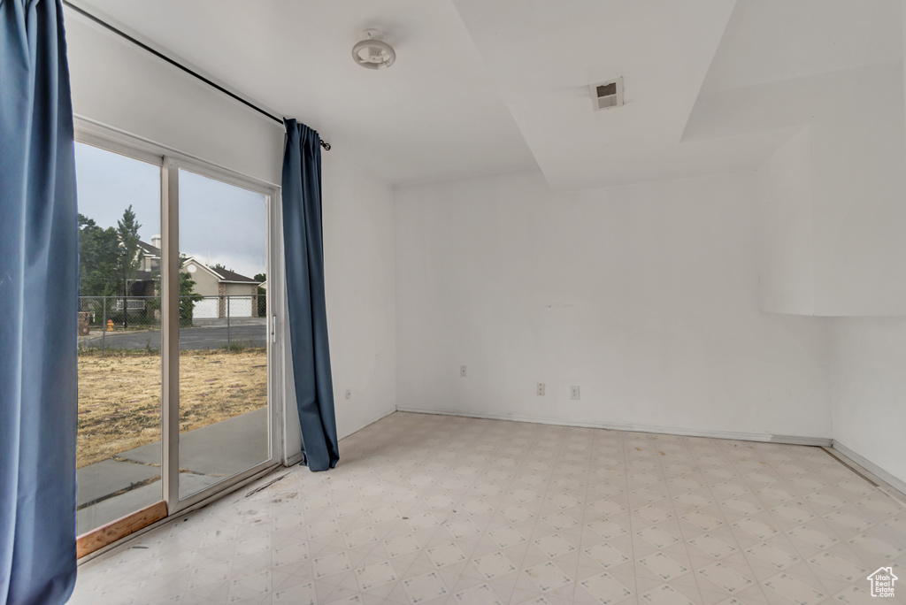 Unfurnished room featuring light floors and baseboards