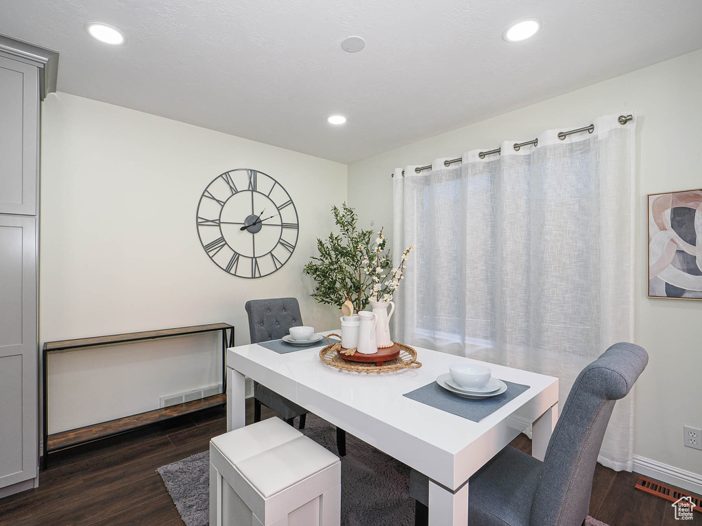 Dining area with dark wood-style flooring, a desk, and recessed lighting