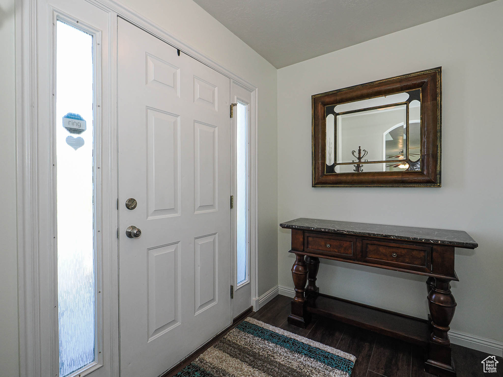 Foyer entrance featuring baseboards and dark wood-style floors