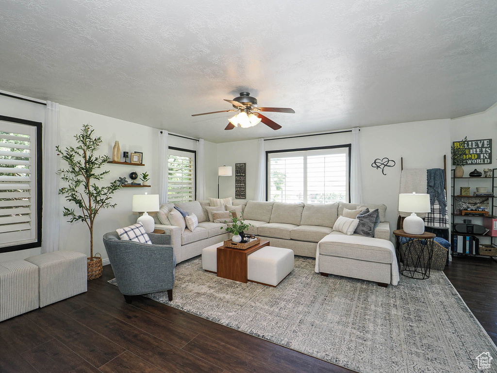 Living area with dark wood finished floors, ceiling fan, and a textured ceiling
