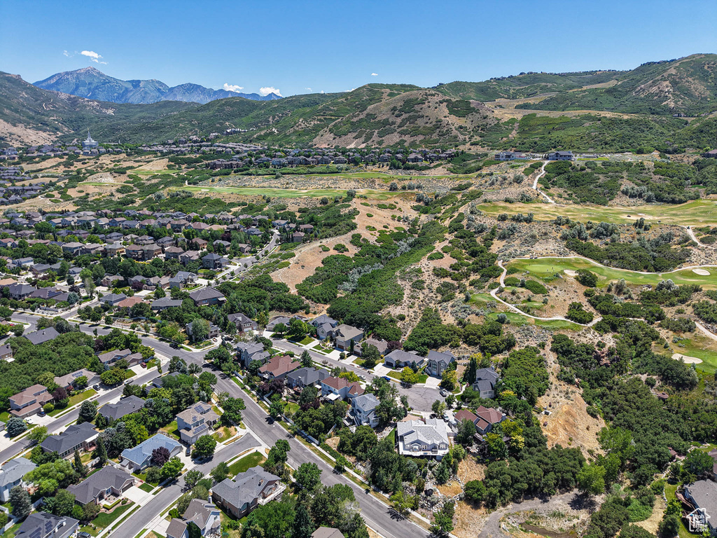 Aerial view of property and surrounding area with a mountain backdrop and nearby suburban area
