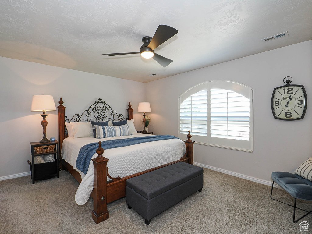 Carpeted bedroom featuring baseboards and ceiling fan