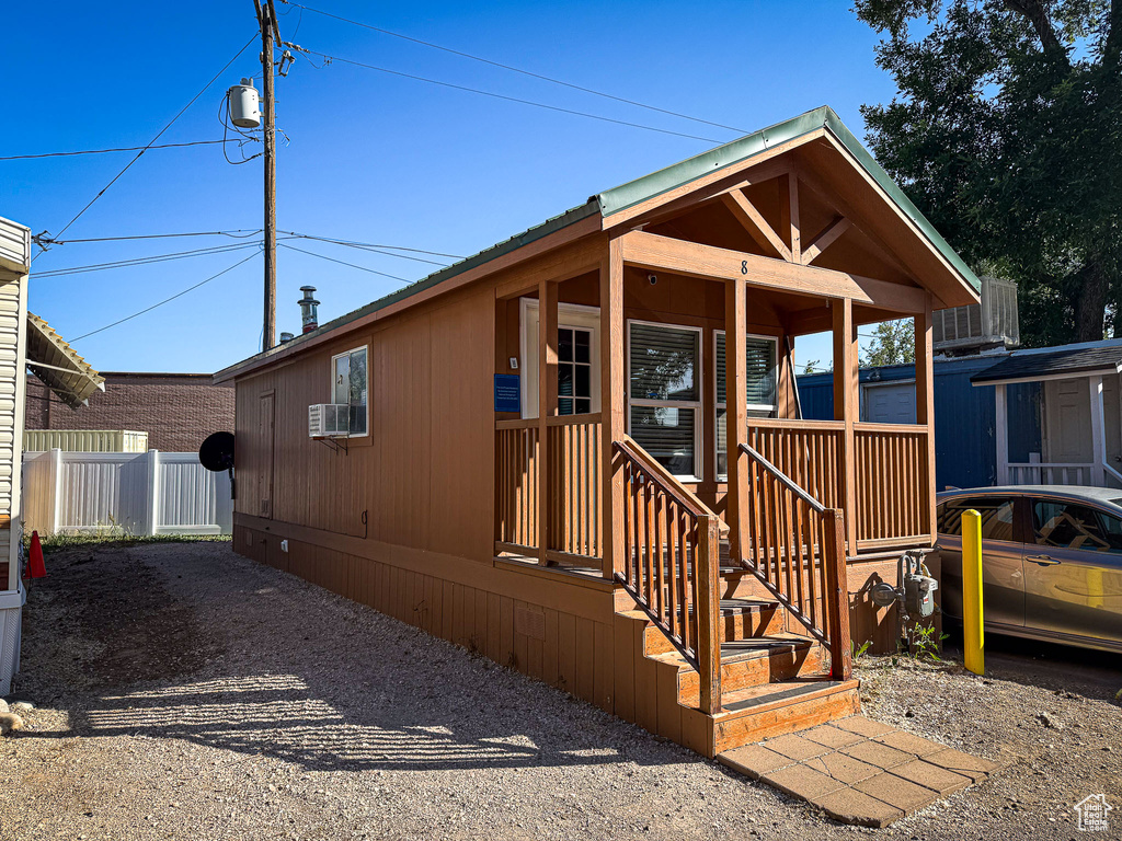 View of front of house featuring a porch and cooling unit