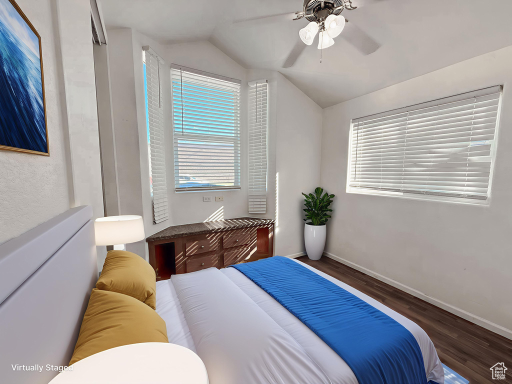 Bedroom featuring lofted ceiling, wood finished floors, and a ceiling fan