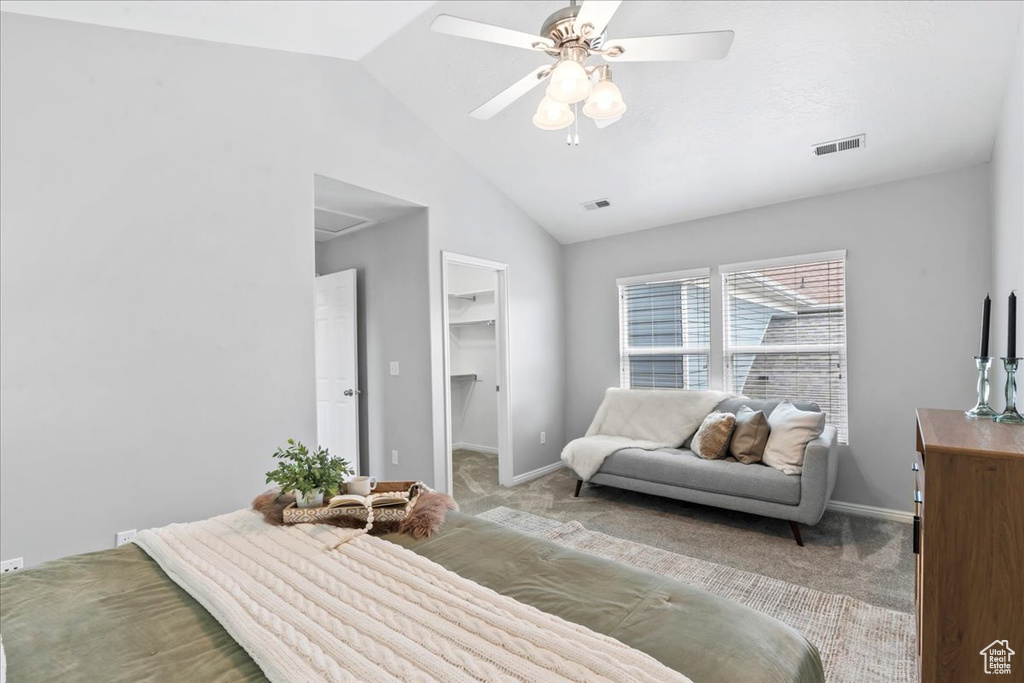 Bedroom featuring light carpet, lofted ceiling, a spacious closet, a ceiling fan, and a closet