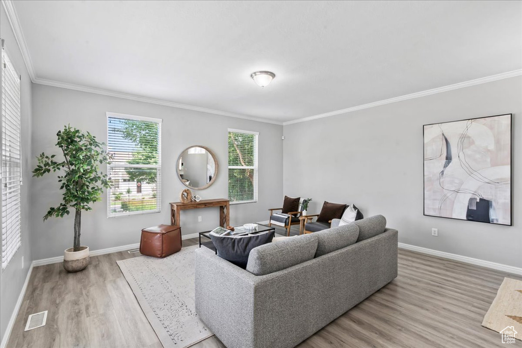 Living room with wood finished floors and ornamental molding