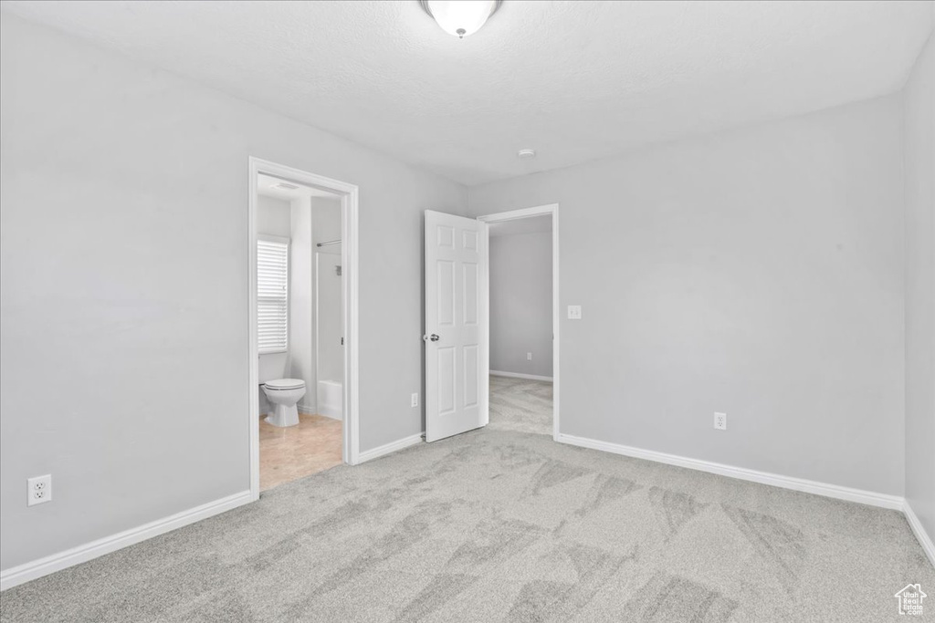Unfurnished bedroom featuring carpet floors and connected bathroom