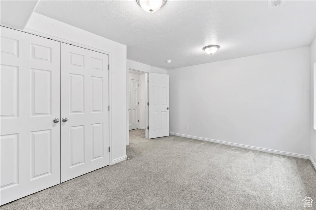 Unfurnished bedroom with carpet and a closet