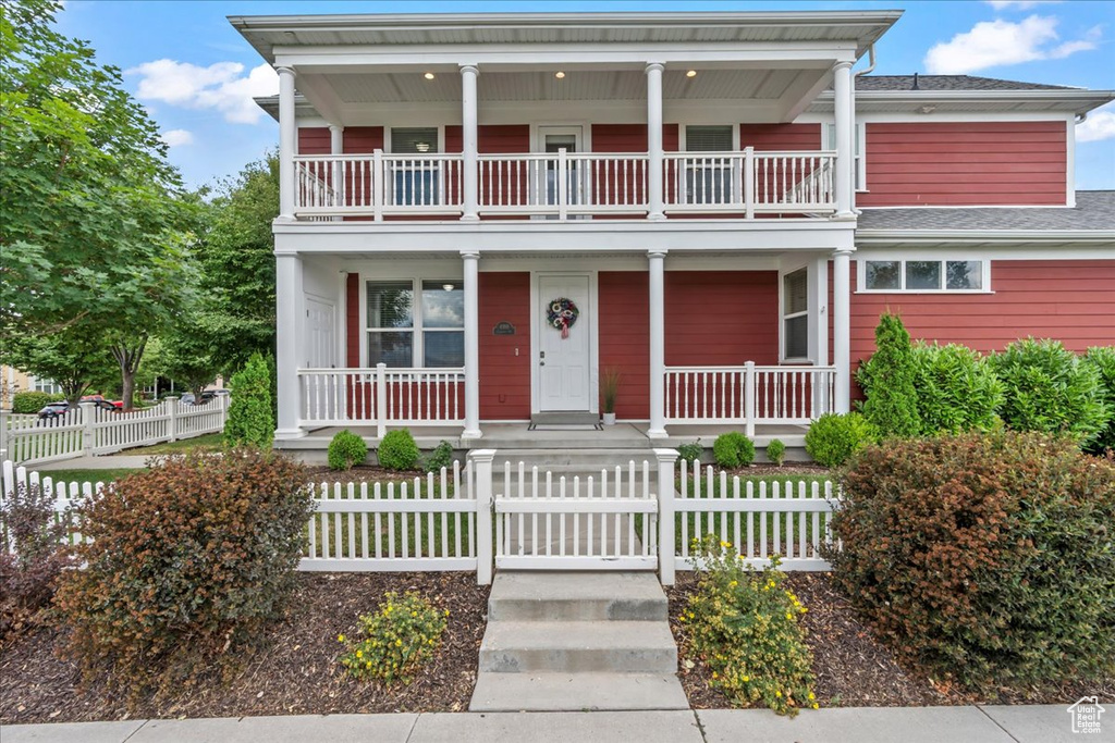 View of front of home featuring a balcony, a porch, and roof with shingles