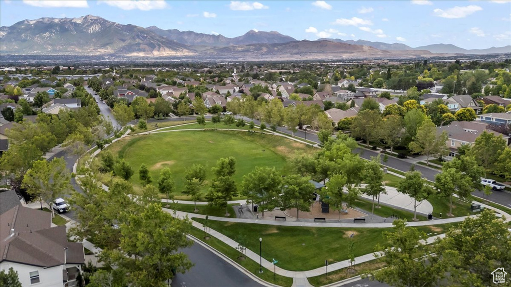 Aerial view of property and surrounding area with nearby suburban area and a mountain backdrop