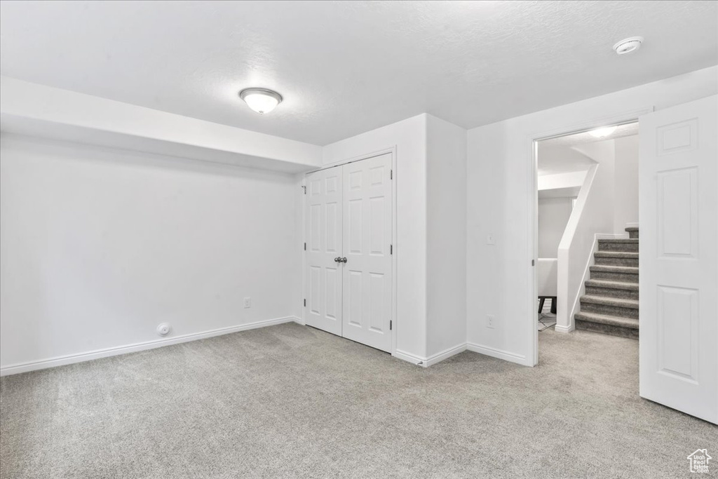 Finished below grade area with carpet flooring and stairway