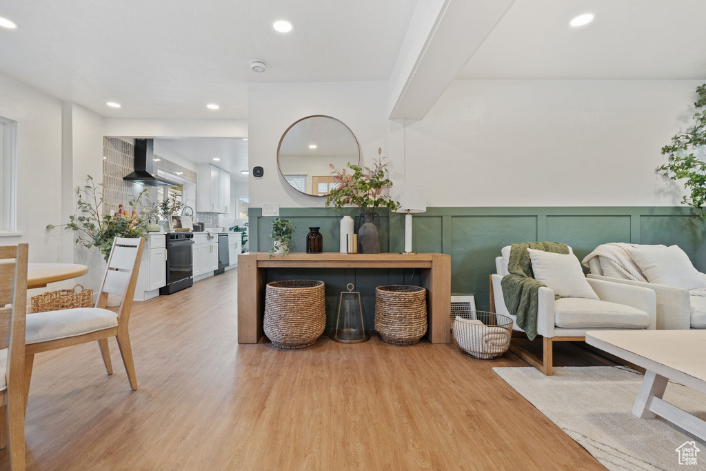 Interior space featuring light wood-type flooring, recessed lighting, a decorative wall, and wainscoting