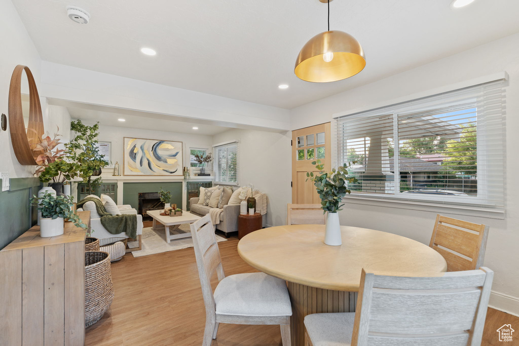 Dining area featuring light wood-style flooring, recessed lighting, and a fireplace