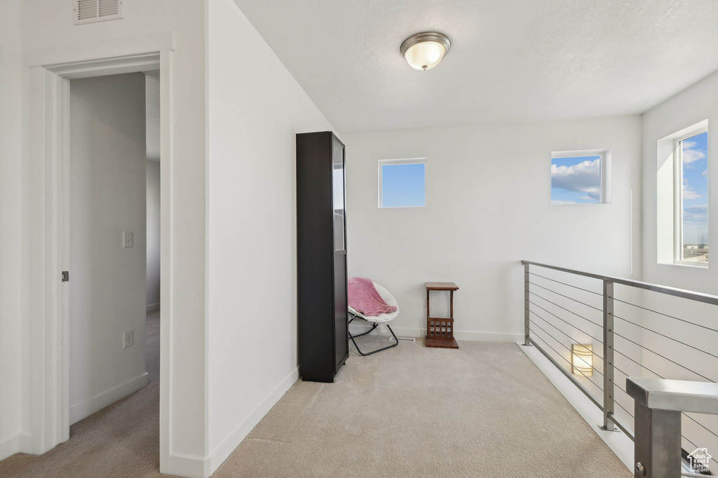 Unfurnished room with carpet and an upstairs landing
