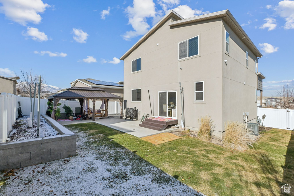 Rear view of property featuring a patio, a gazebo, a fenced backyard, and stucco siding