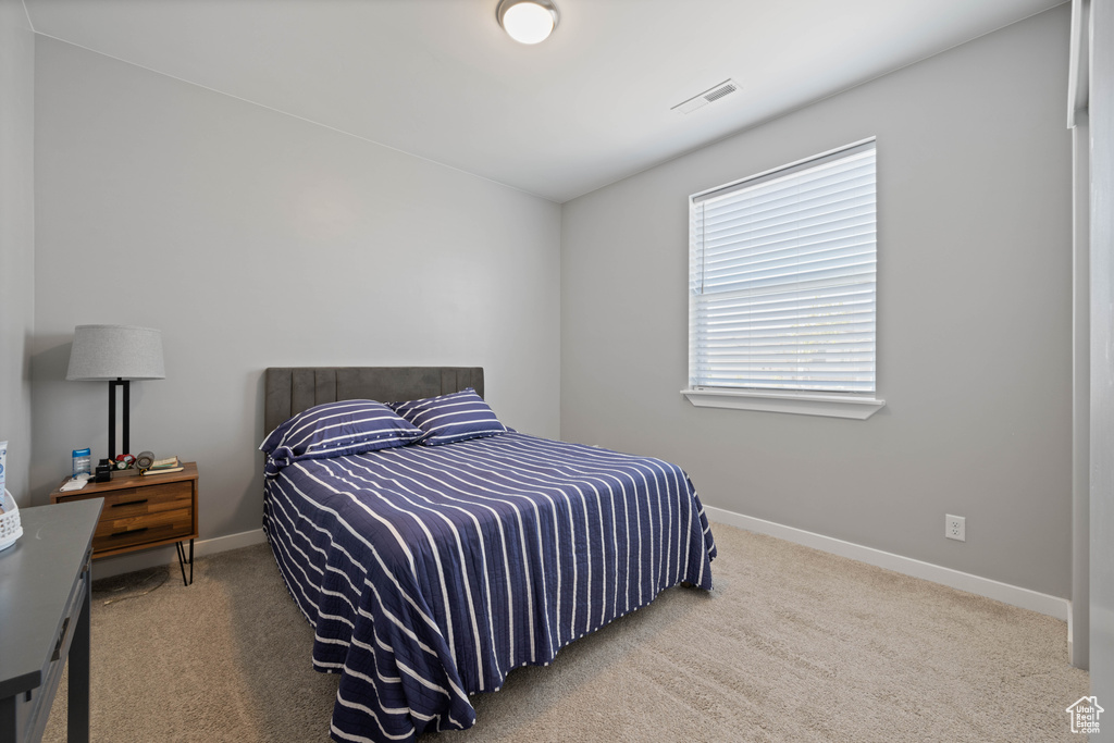 Bedroom featuring carpet and baseboards