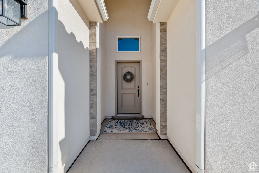 Property entrance with stone siding and stucco siding