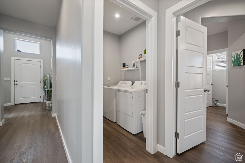 Washroom featuring washer and clothes dryer and dark wood-style floors
