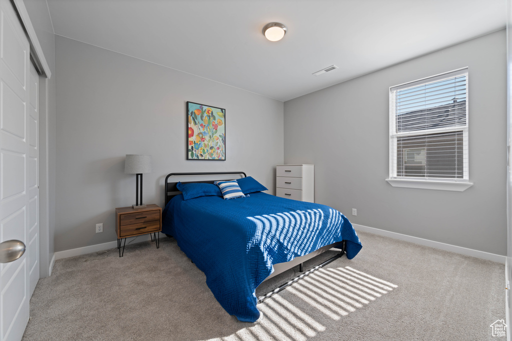 Carpeted bedroom with a closet and baseboards