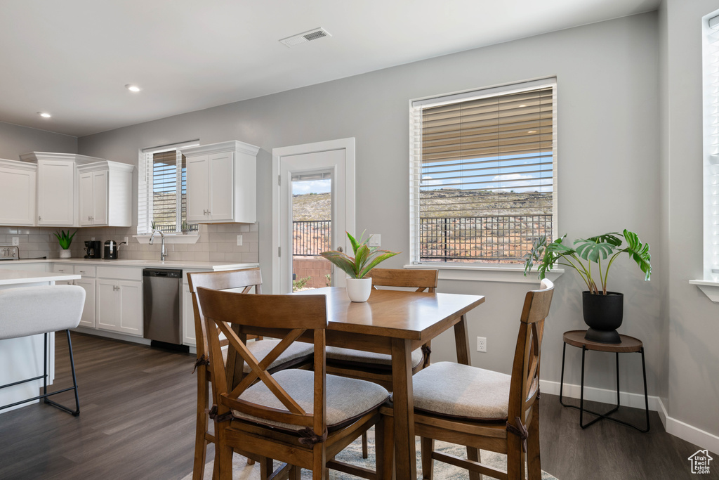 Dining space with dark wood-type flooring and recessed lighting