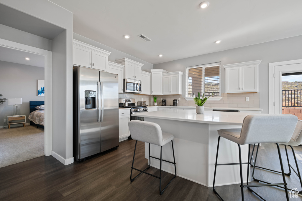 Kitchen featuring stainless steel appliances, healthy amount of natural light, white cabinets, and recessed lighting