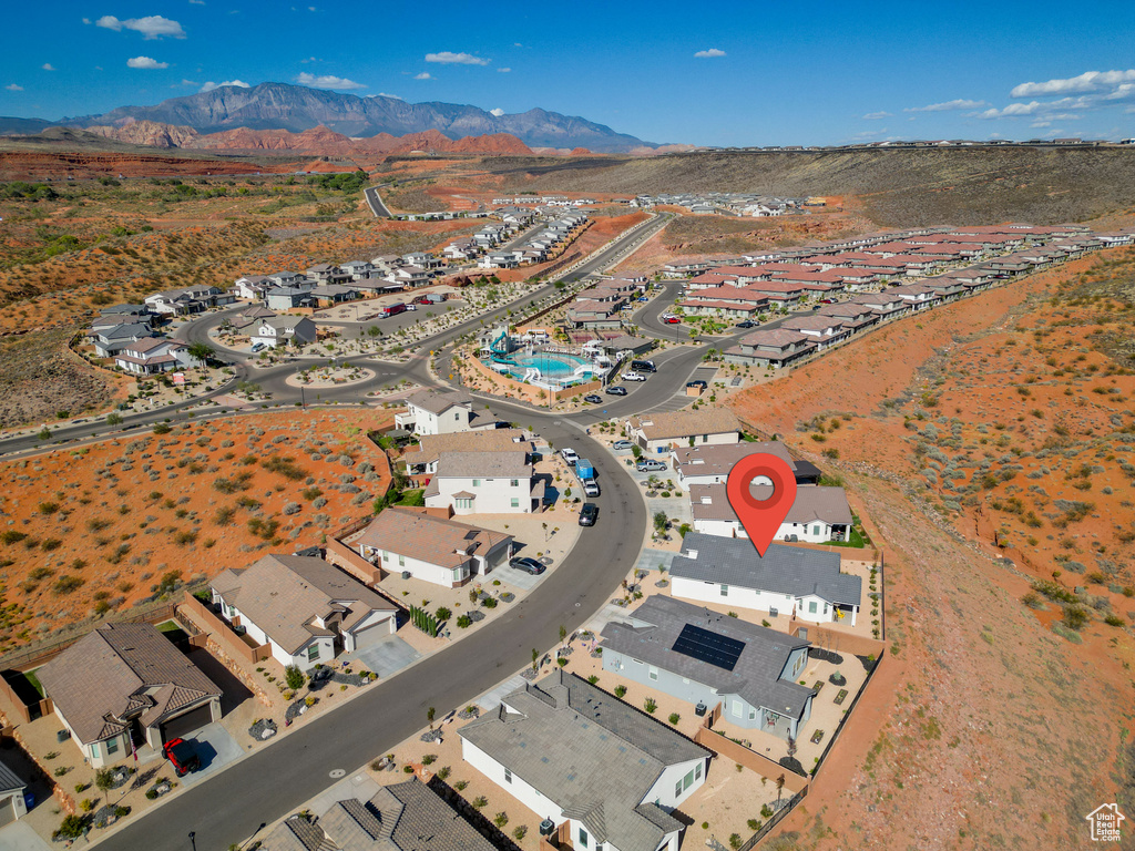 Aerial overview of property's location with a mountainous background and nearby suburban area