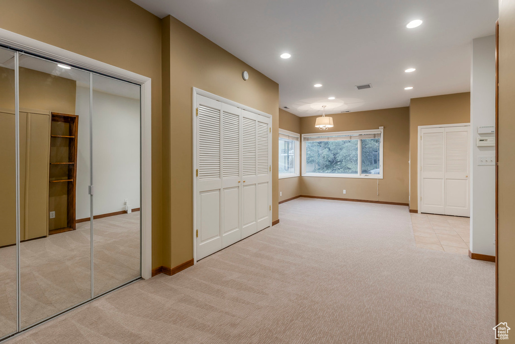 Unfurnished bedroom with carpet flooring, recessed lighting, and multiple closets